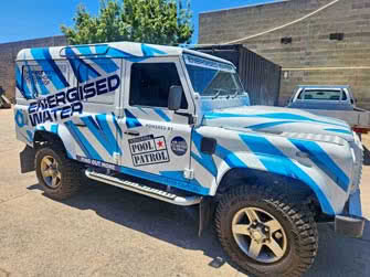 Custom business graphics wrap on a Landrover 110 vehicle, side view, belongs to Adelaide Pool Patrol Energized Water