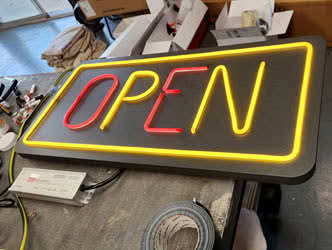 Lit up Open sign on a workbench