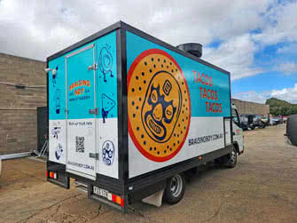 View from behind/right side of a food truck belonging to Braising Boy, outside on an overcast day